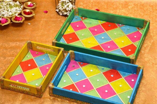 A vibrant multicolor Holi hamper tray filled with assorted sweets and snacks.