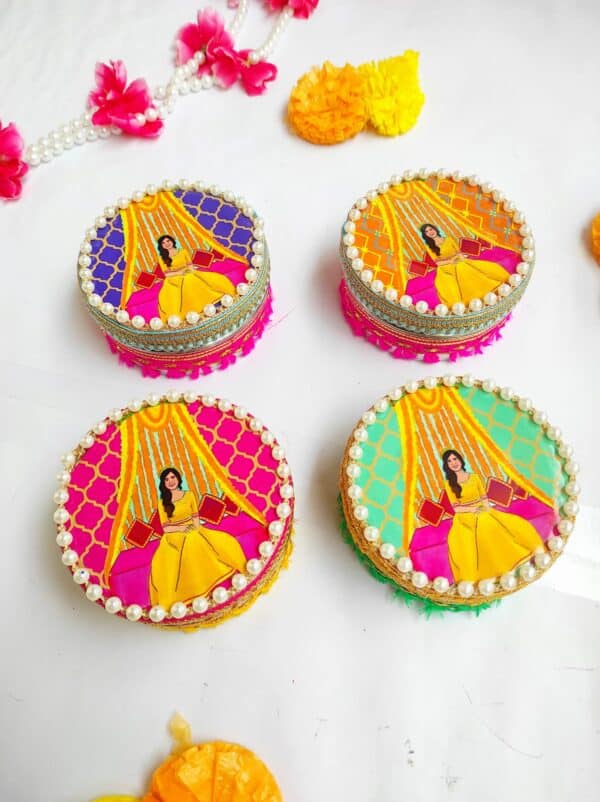 Elegant Haldi-themed sweet boxes adorned with yellow and gold designs, filled with traditional Indian sweets, perfect for return gifts at Haldi ceremonies